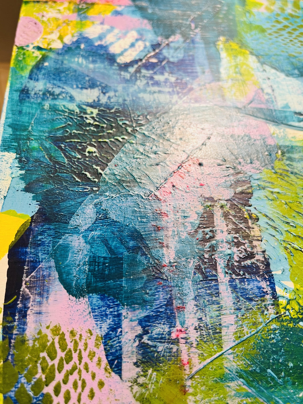 Abstract mixed-media painting with layered brushstrokes in blue, teal, pink, yellow, green, and gray, featuring textured paint application and collage-like elements.