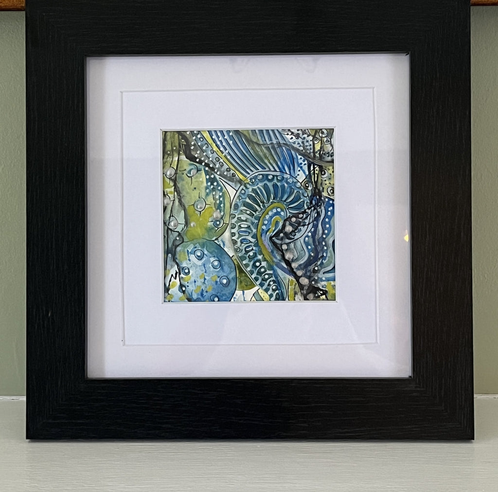 Framed abstract artwork with blue and green colors on a white background